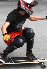 Skateboarder with full face helmet, knee pads and gloves