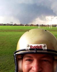 Wearing football helmet with tornado in background