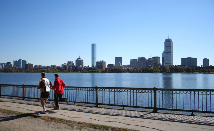 Joggers along Charles River with Boston skyline in background