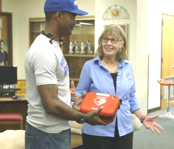 Brooke de Lench donating AED to Ira Carter of Grand Prairie TX Youth Football