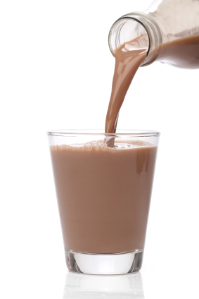 Chocolate milk being poured into glass from bottle
