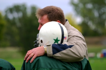 Coach with arm around youth football player