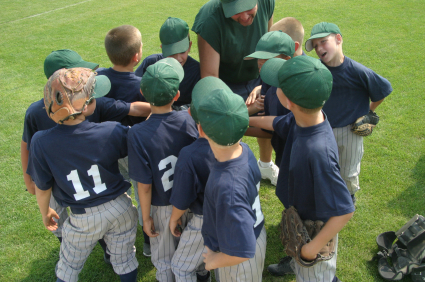 Little League players and coach in pregame huddle