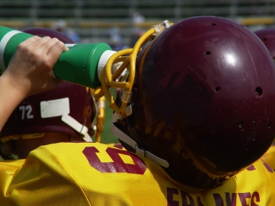 Young football player drinking from squeeze bottle