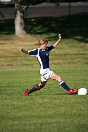 Girl stretching for soccer ball