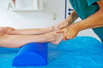 Physical therapist testing patient's ankles