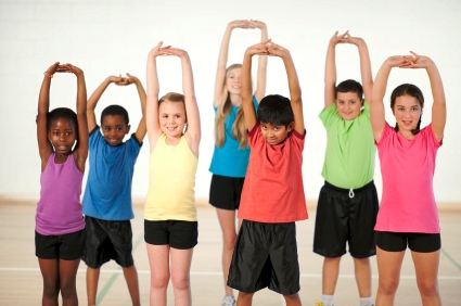 School children stretching in gym