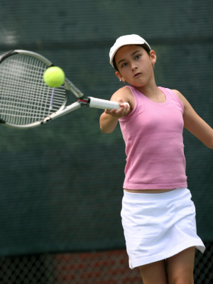 Teenage tennis player about to hit ball