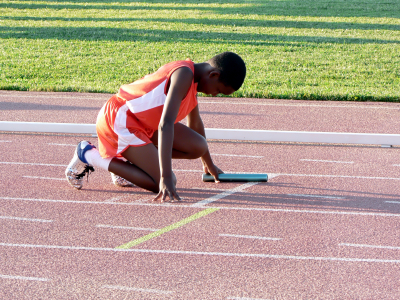 Track athlete in starting blocks of relay race