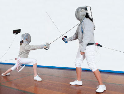 Two young female fencers competing in saber