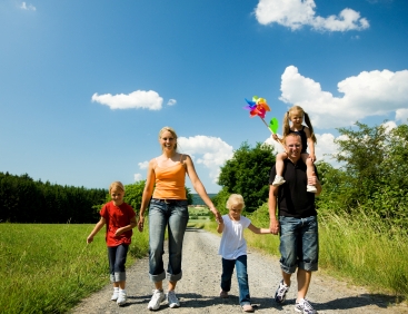 Family walking on bright sunny summer day
