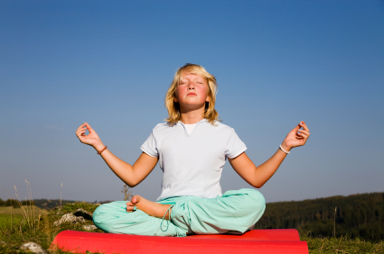 Young girl in yoga pose facing sun