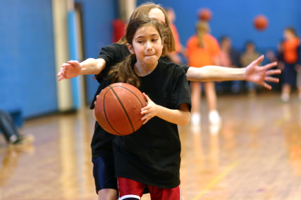 Young girl basketball player being guarded