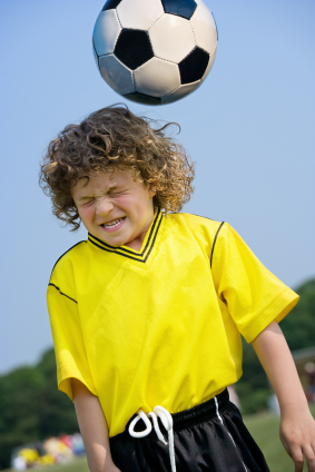 Child heading soccer ball