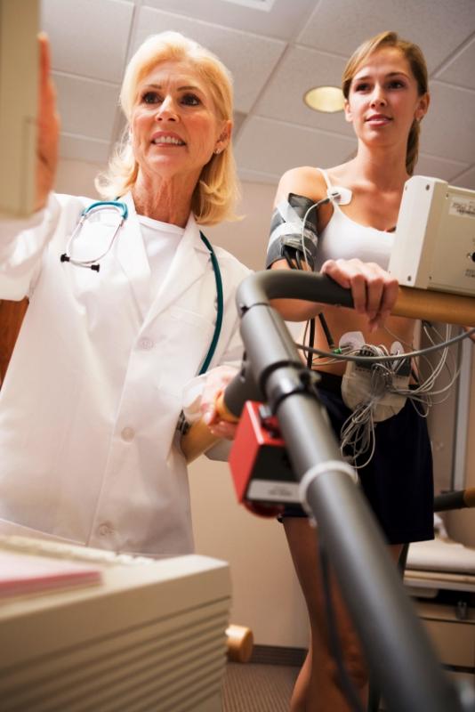 Doctor and young woman on treadmill