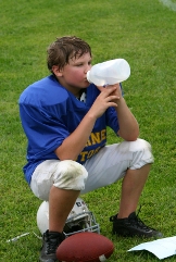 Youth football player drinking from a bottle