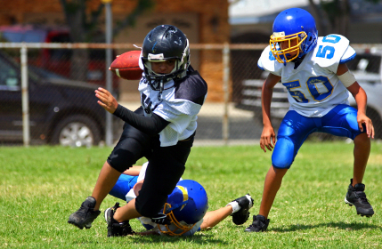 Youth football player breaking a tackle