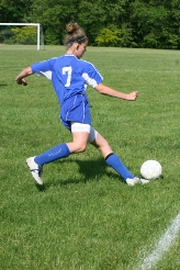 Female soccer player about to kick a ball