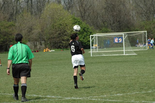 Female soccer player heading soccer ball