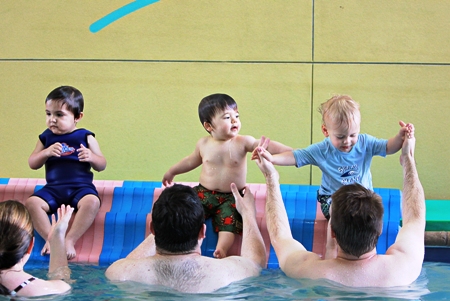 Fathers teaching their infants water safety