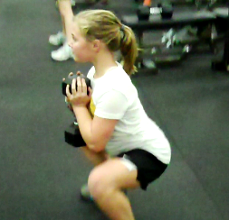 Young girl performing squats with weights