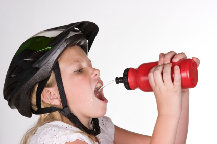 Young cyclist drinking water from squirt bottle