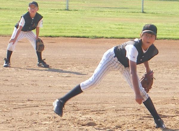 Youth baseball pitcher delivers to plate