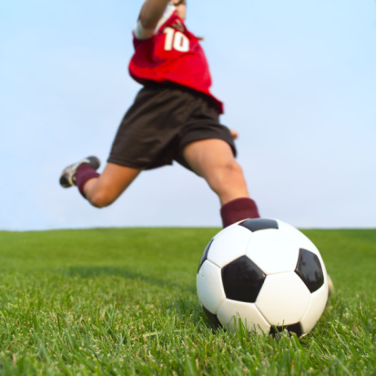 Young female soccer player about to kick ball