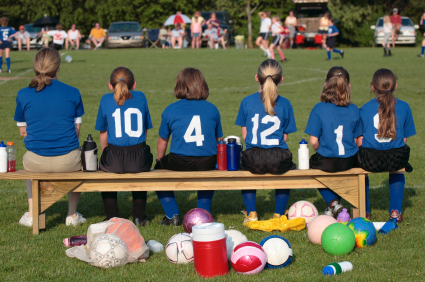 Girl soccer players sitting on bench