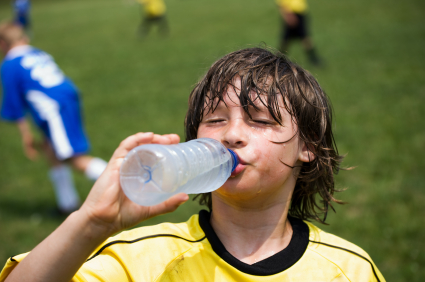 Soccer player drenched in sweat drinking water