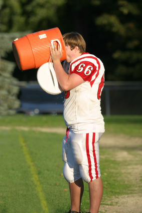 Football player drinking from Gatorade jug